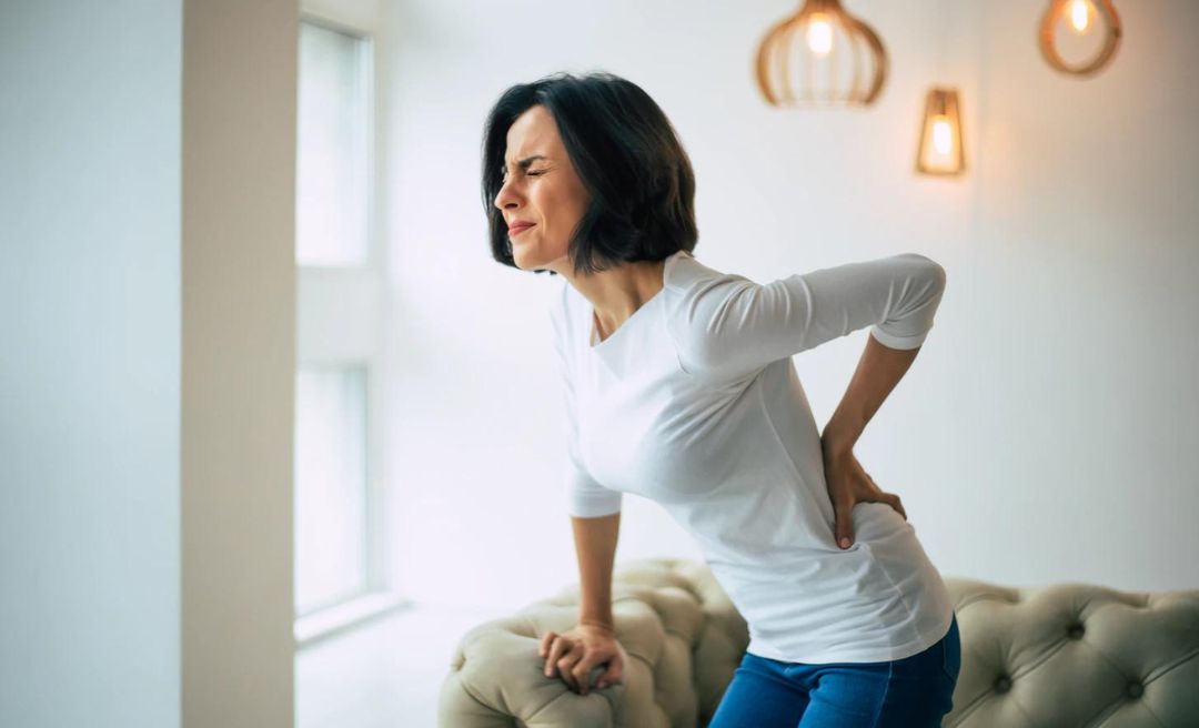 woman hunched over from back pain in women over 40